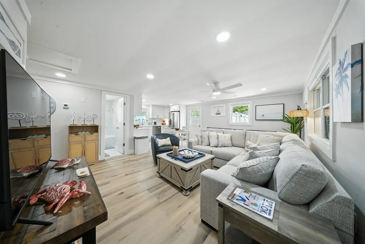 Coastal-style living room with a light sectional sofa, wood floors and recessed lighting in a Charlotte home, photographed by Luma Real Estate Media