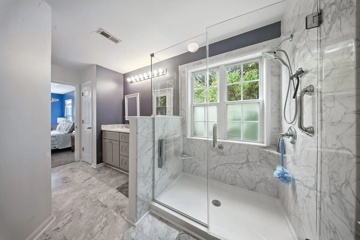 Primary bathroom with a frameless glass walk-in shower and marble tile, HDR photographed by Luma Real Estate Media