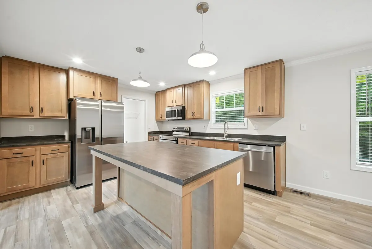 Mooresville kitchen with wood cabinets, stainless appliances and a center island, photographed by Luma Real Estate Media